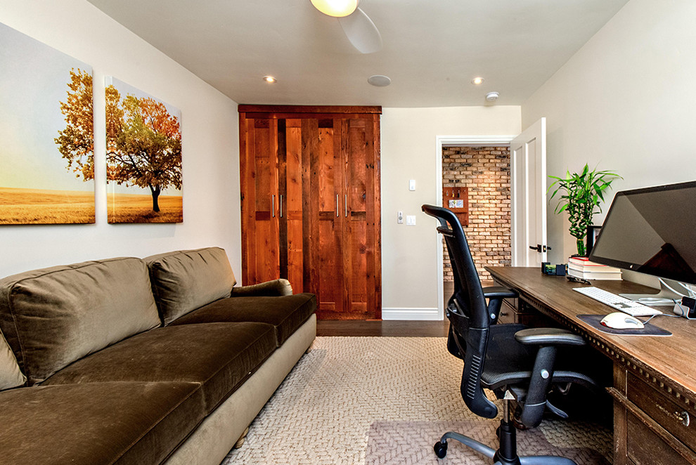 Imagen de despacho minimalista de tamaño medio con paredes beige, suelo de madera oscura y escritorio independiente