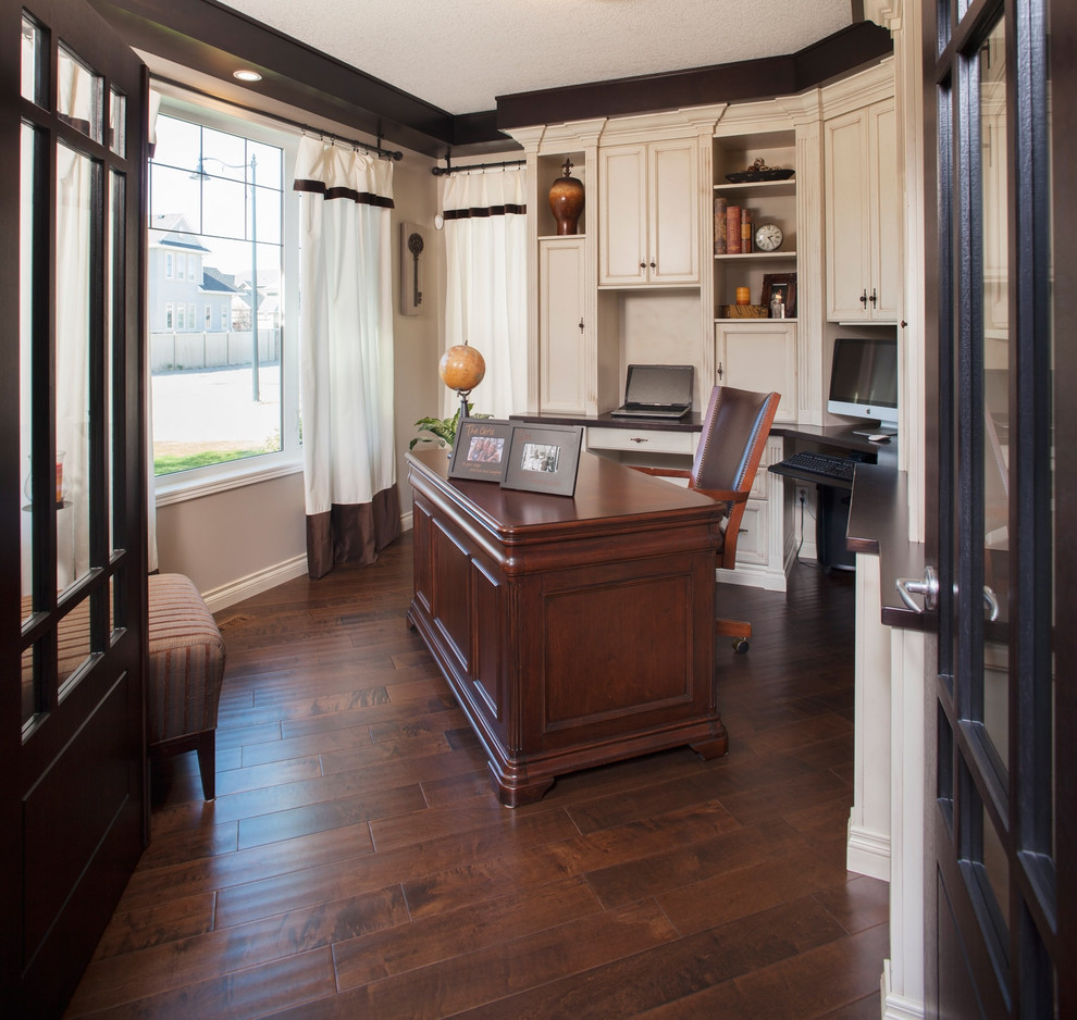 Imagen de despacho clásico de tamaño medio sin chimenea con paredes marrones, suelo de madera oscura, escritorio independiente y suelo marrón