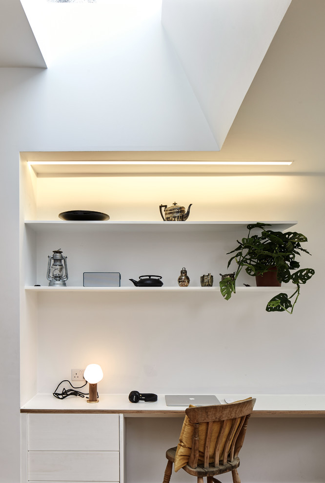 Scandi study in London with white walls and a built-in desk.
