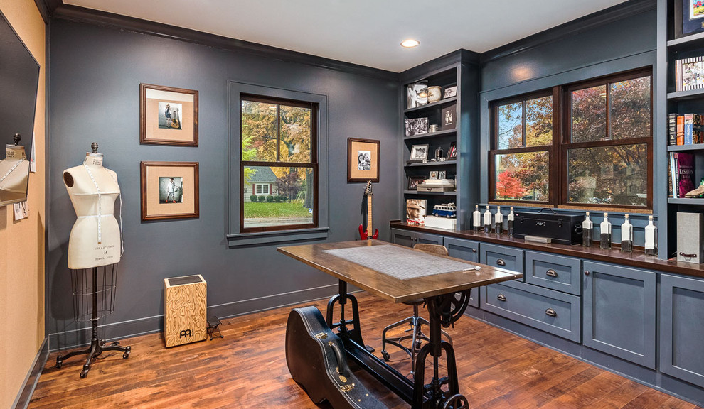 Craft room - craftsman freestanding desk medium tone wood floor and brown floor craft room idea in Kansas City with blue walls and no fireplace
