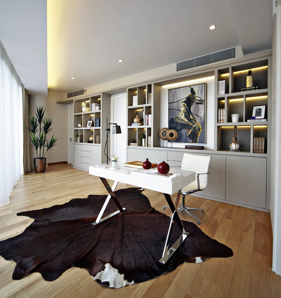 Example of a trendy freestanding desk medium tone wood floor home office design in Singapore with no fireplace