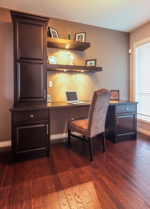 Cette image montre un bureau traditionnel de taille moyenne avec un mur gris, parquet foncé, aucune cheminée, un bureau intégré et un sol marron.