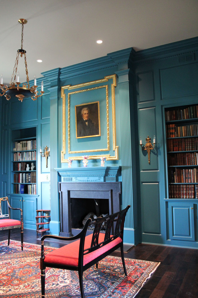 Klassisches Arbeitszimmer mit Arbeitsplatz, blauer Wandfarbe, dunklem Holzboden, Kamin und Kaminumrandung aus Stein in Indianapolis