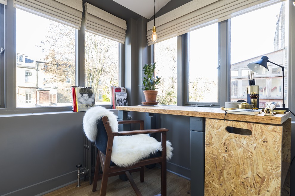 Cette photo montre un petit bureau scandinave avec un mur gris, un sol en bois brun, aucune cheminée et un bureau indépendant.