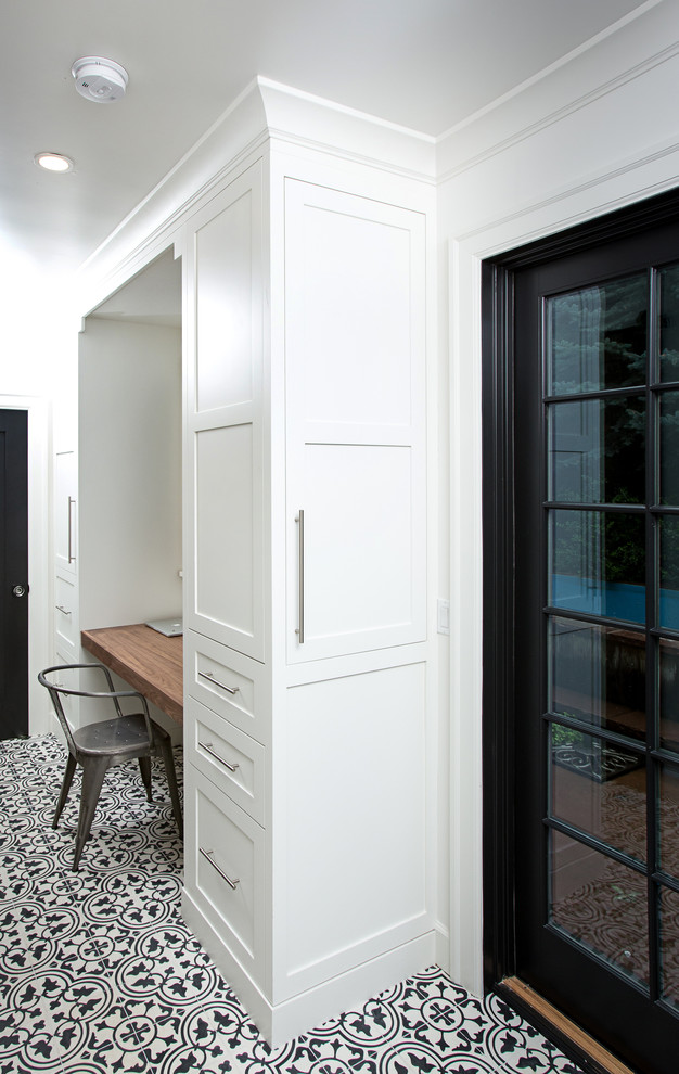 На фото: маленькое рабочее место в стиле неоклассика (современная классика) с белыми стенами, полом из керамической плитки и встроенным рабочим столом для на участке и в саду