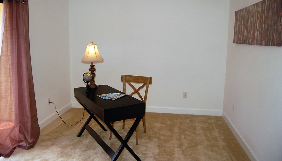 Medium sized classic study in Orlando with beige walls, carpet, no fireplace and a freestanding desk.