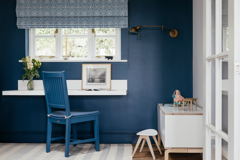 Kleines Maritimes Arbeitszimmer mit blauer Wandfarbe, braunem Holzboden, braunem Boden und Einbau-Schreibtisch in Cornwall