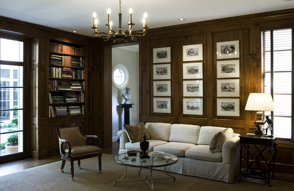 На фото: домашняя библиотека среднего размера в классическом стиле с коричневыми стенами и темным паркетным полом без камина с