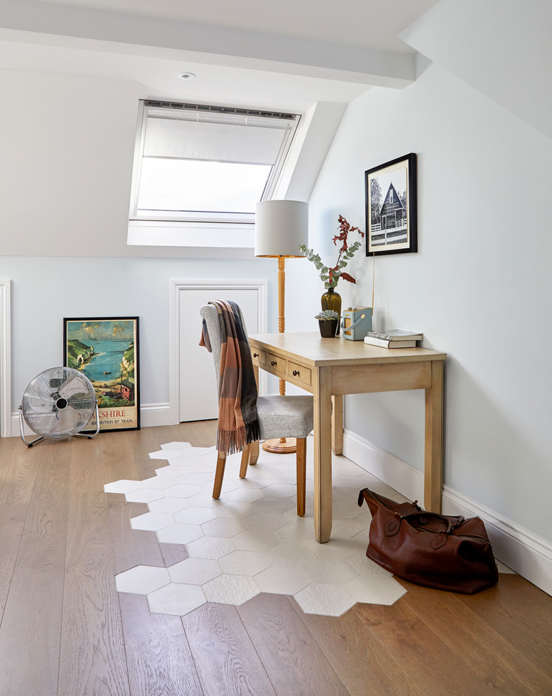 Klassisches Arbeitszimmer mit blauer Wandfarbe, braunem Holzboden, freistehendem Schreibtisch und braunem Boden in London