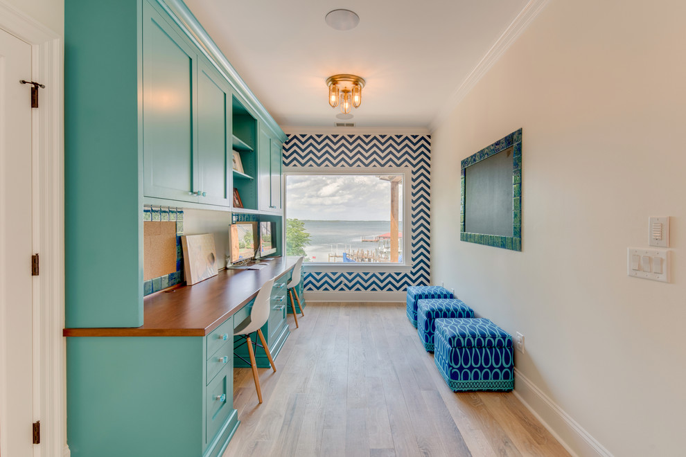 Ejemplo de despacho clásico renovado de tamaño medio con paredes multicolor, suelo de madera clara y escritorio empotrado