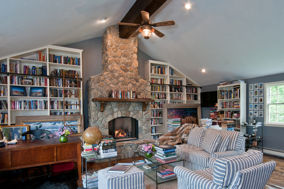 Photo of a large bohemian study in Boston with blue walls, dark hardwood flooring, a standard fireplace, a stone fireplace surround and a freestanding desk.