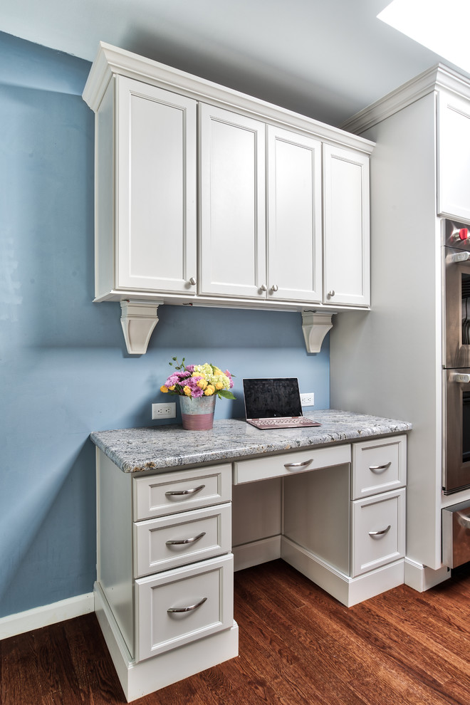 Ejemplo de estudio tradicional renovado pequeño con paredes azules, suelo de madera oscura, escritorio empotrado y suelo marrón