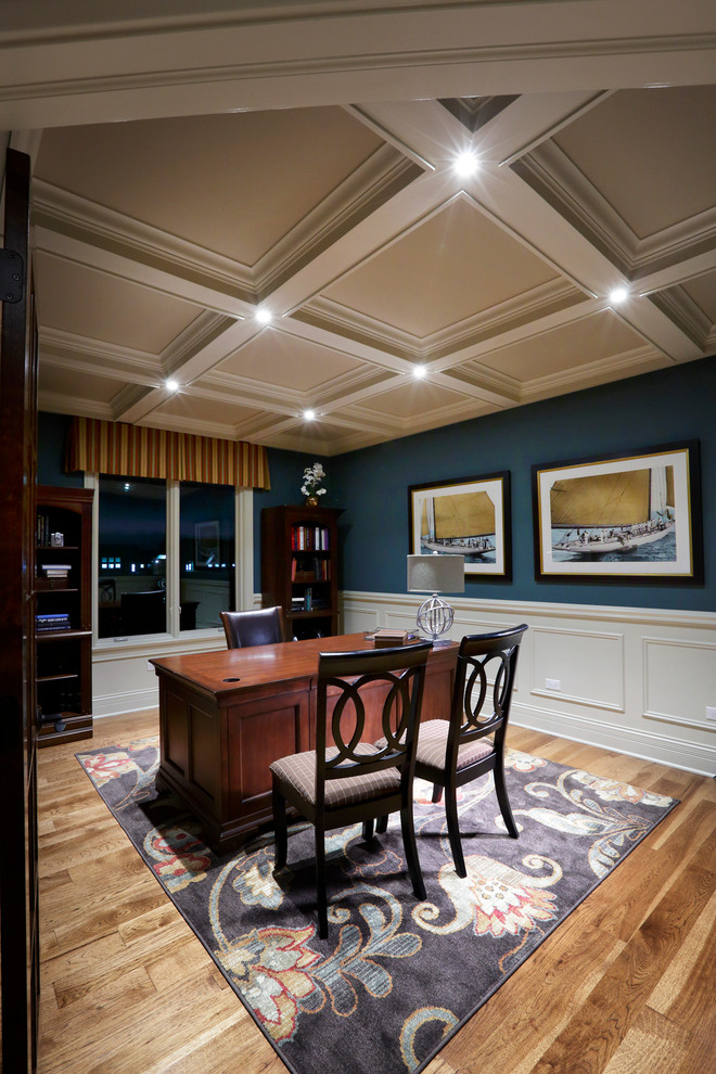 Cette photo montre un bureau chic de taille moyenne avec un mur bleu, parquet clair, un bureau indépendant et aucune cheminée.