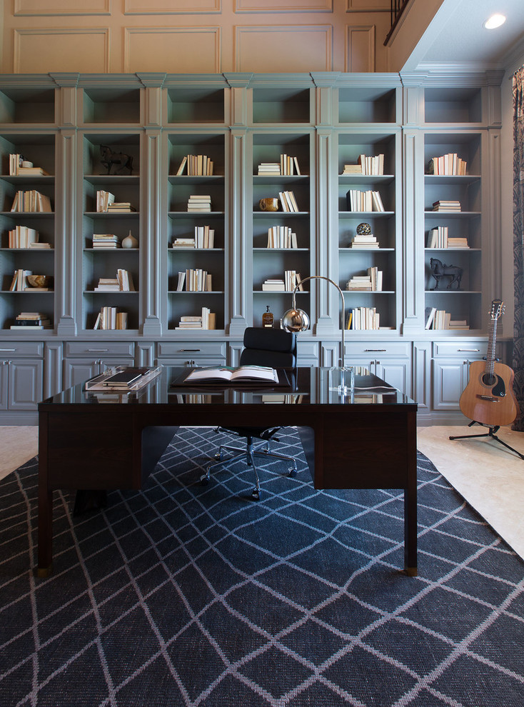 На фото: большой домашняя библиотека в стиле неоклассика (современная классика) с отдельно стоящим рабочим столом