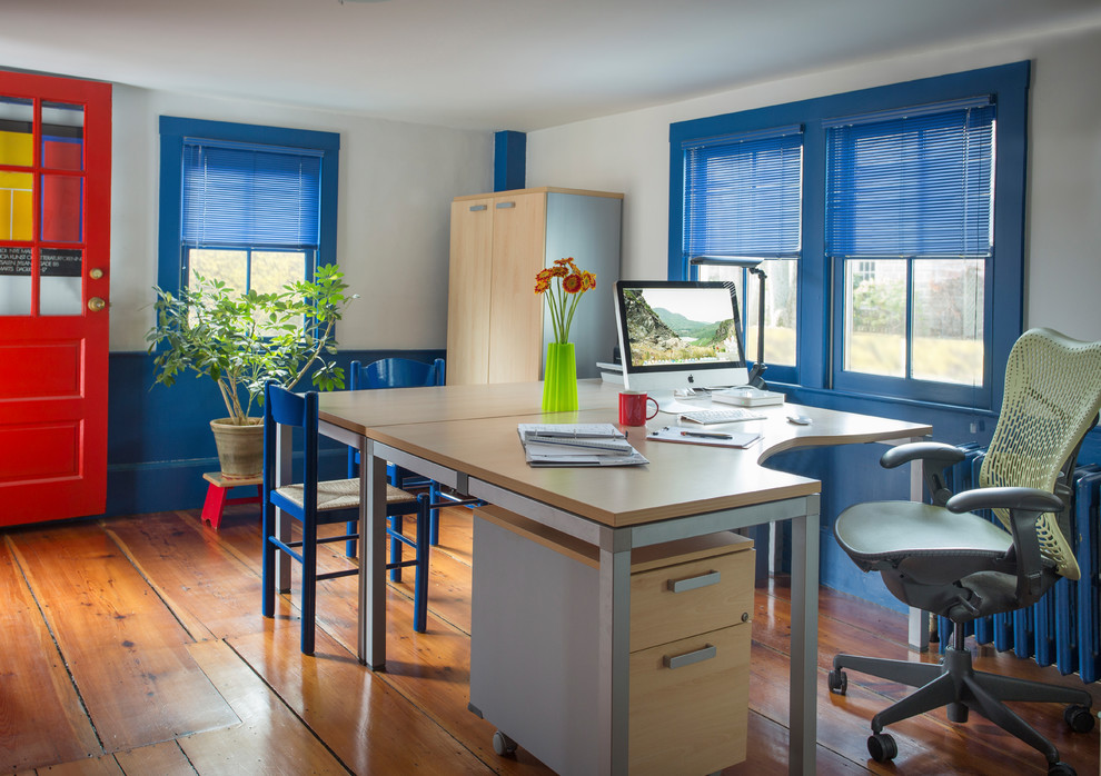 Aménagement d'un bureau classique avec un mur bleu, un sol en bois brun, aucune cheminée, un bureau indépendant et un sol marron.
