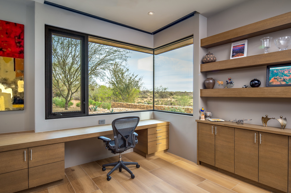 Foto de despacho contemporáneo con paredes grises, suelo de madera clara, escritorio empotrado y suelo beige