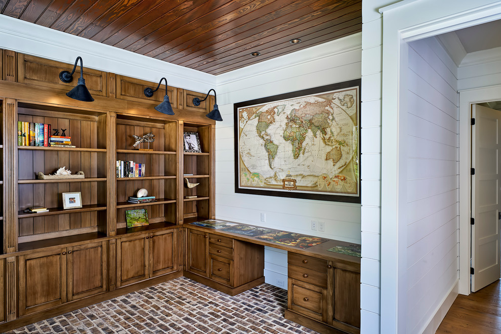 Photo of a country study in Atlanta with white walls, brick flooring and a built-in desk.