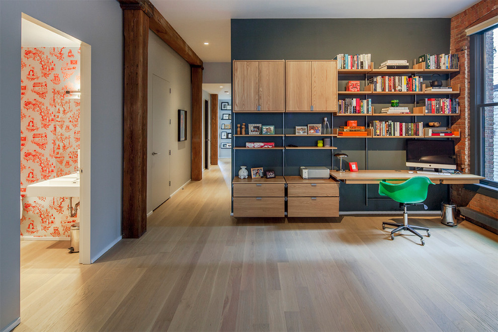 Bild på ett mellanstort industriellt arbetsrum, med grå väggar, ljust trägolv och ett inbyggt skrivbord