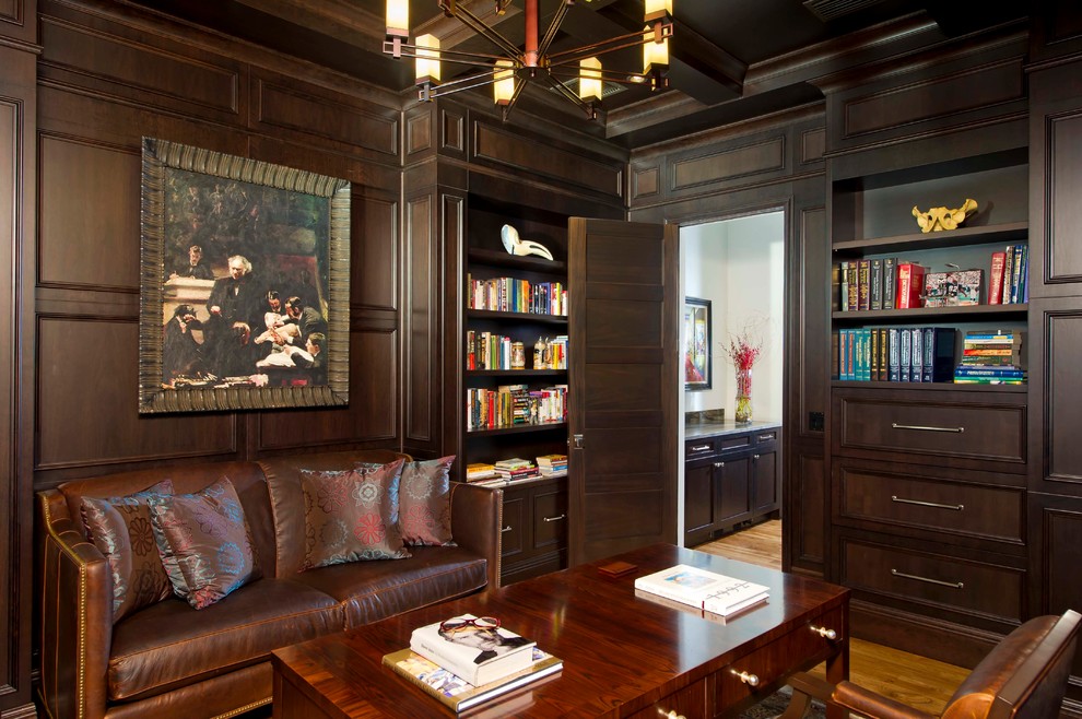 Imagen de despacho clásico con paredes marrones y suelo de madera en tonos medios