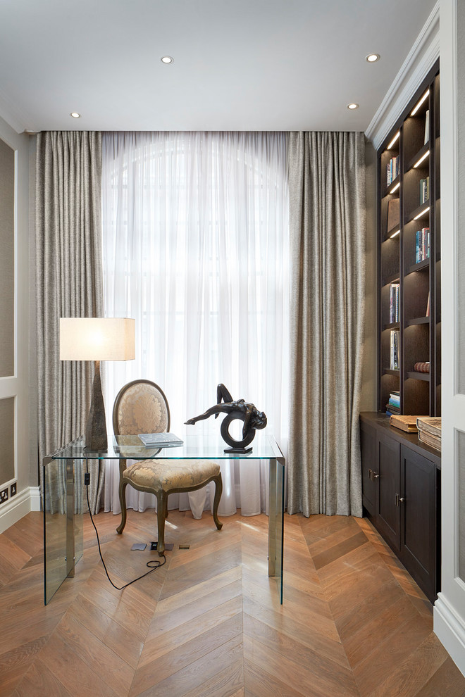 Klassisches Lesezimmer ohne Kamin mit hellem Holzboden und freistehendem Schreibtisch in London