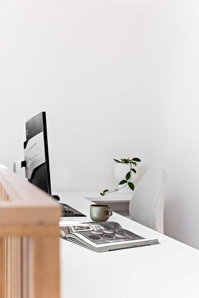 Esempio di un piccolo ufficio minimal con pareti bianche, parquet chiaro e scrivania incassata