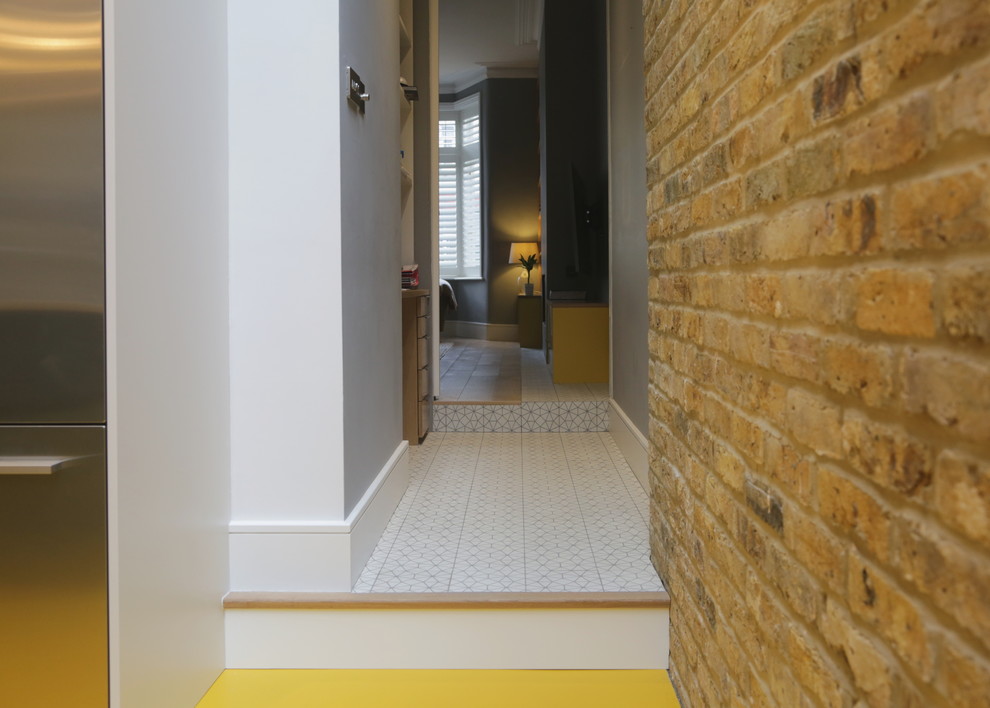 ロンドンにあるお手頃価格の小さなコンテンポラリースタイルのおしゃれな書斎 (グレーの壁、セラミックタイルの床、造り付け机、白い床) の写真