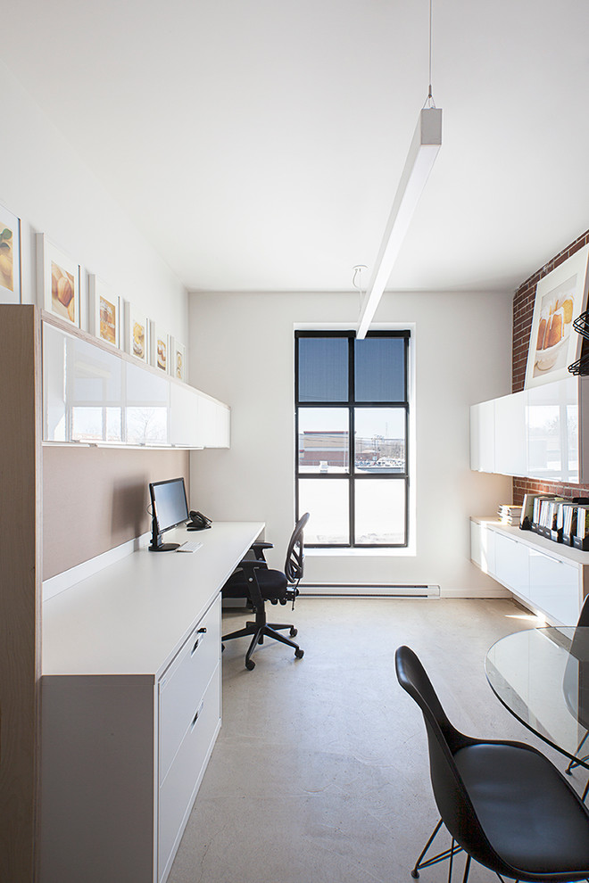 Foto de despacho minimalista de tamaño medio con paredes blancas, suelo de cemento y escritorio independiente