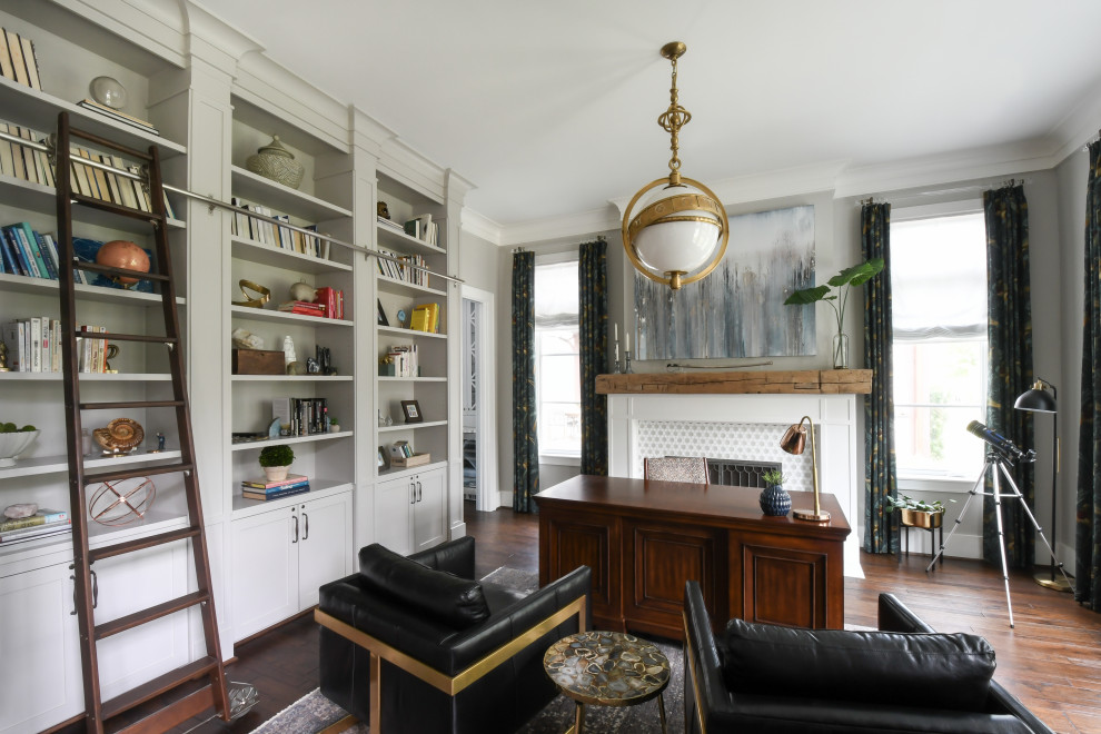 Cette image montre un bureau traditionnel avec un mur beige, un sol en bois brun, une cheminée standard, un manteau de cheminée en carrelage, un sol marron et un bureau indépendant.