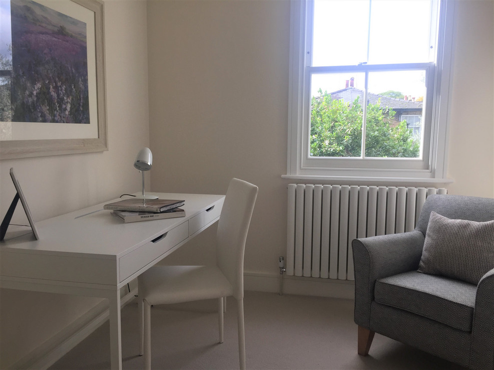 Kleines Modernes Arbeitszimmer mit Arbeitsplatz, beiger Wandfarbe, Teppichboden, freistehendem Schreibtisch und beigem Boden in London
