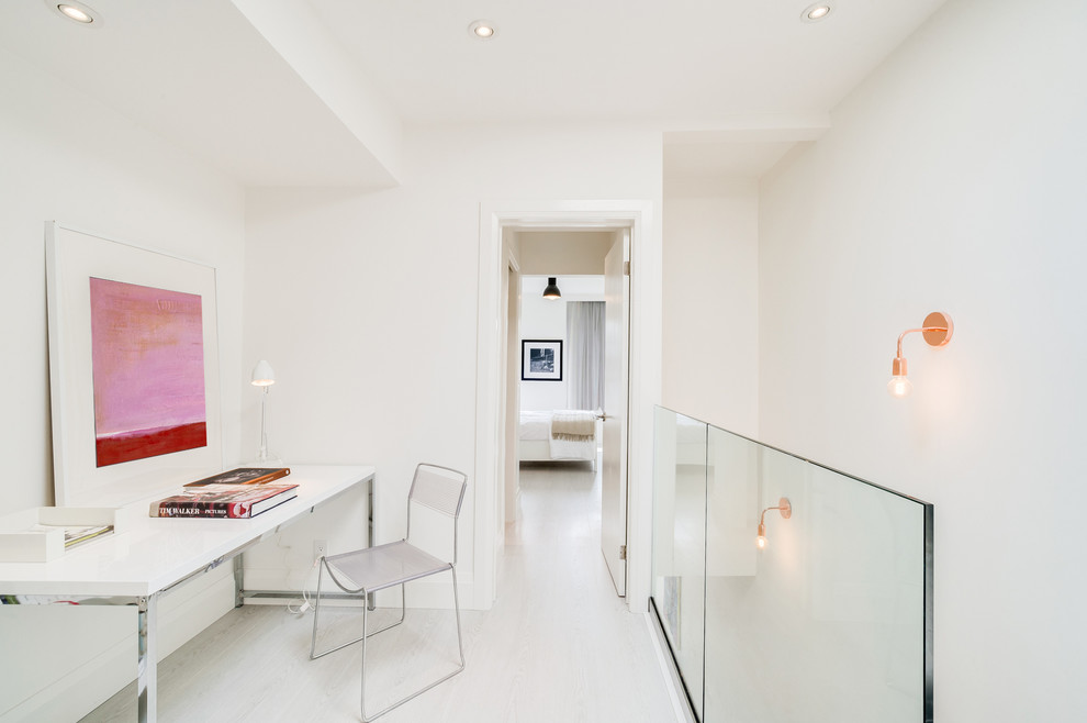 Свежая идея для дизайна: рабочее место среднего размера в стиле модернизм с белыми стенами, полом из ламината, отдельно стоящим рабочим столом и серым полом - отличное фото интерьера