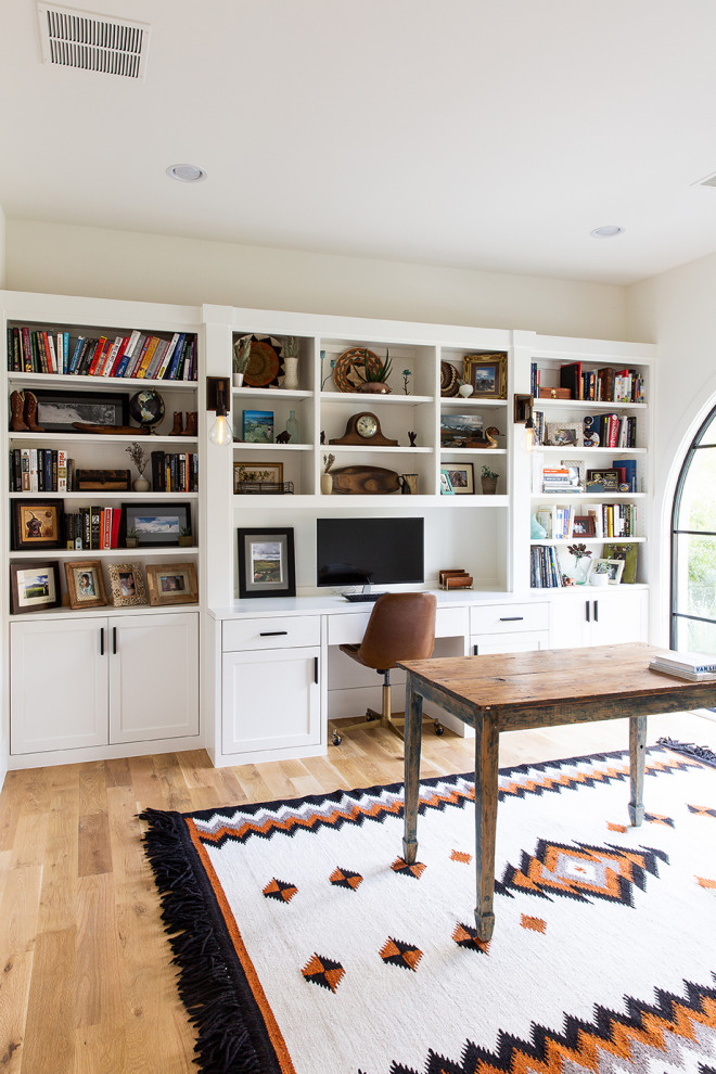 ダラスにある地中海スタイルのおしゃれなホームオフィス・書斎 (ベージュの壁、無垢フローリング、自立型机、茶色い床) の写真