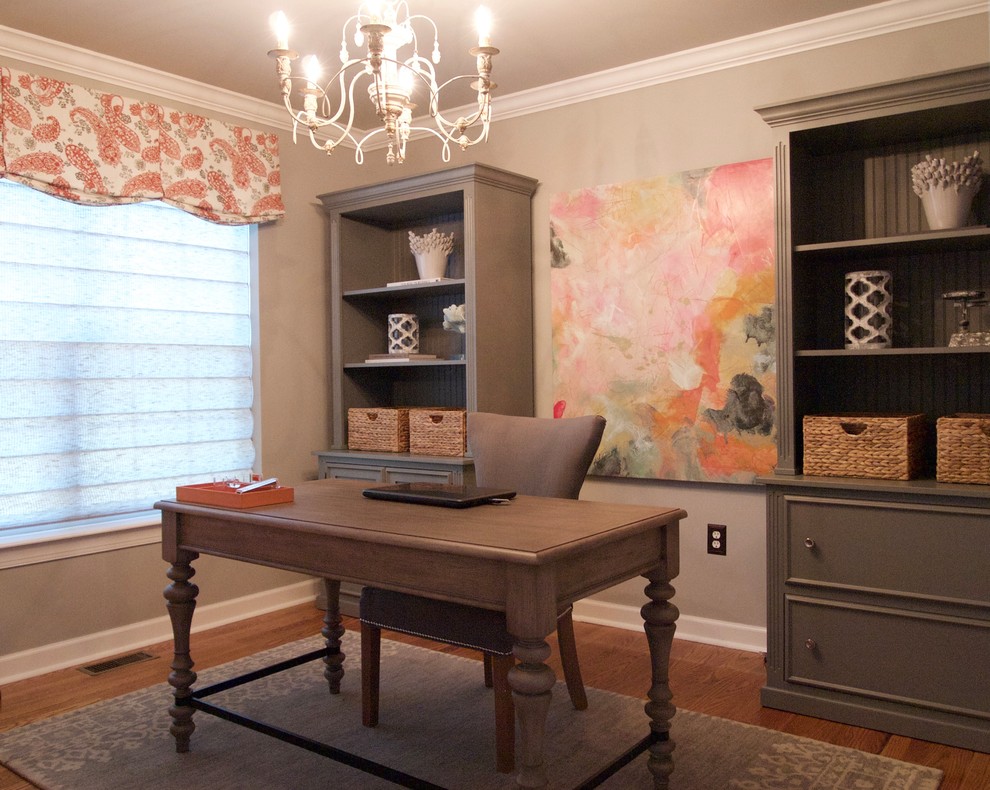 Immagine di un piccolo studio minimal con pareti grigie, pavimento in legno massello medio, scrivania autoportante e pavimento marrone