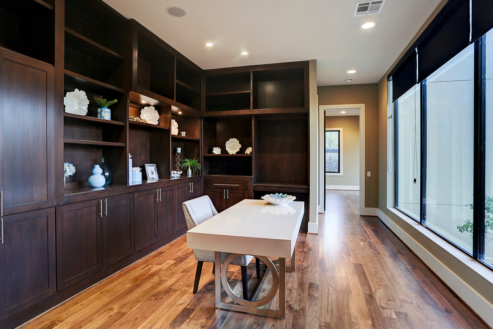 Ejemplo de despacho contemporáneo de tamaño medio sin chimenea con paredes beige, suelo de madera en tonos medios, escritorio independiente y suelo marrón