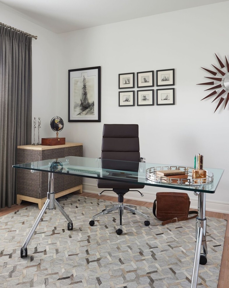 Modelo de despacho retro de tamaño medio sin chimenea con paredes blancas, suelo de madera clara, escritorio independiente y suelo beige