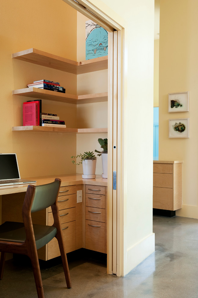 Foto di un piccolo ufficio contemporaneo con pavimento in cemento, scrivania incassata e pareti beige