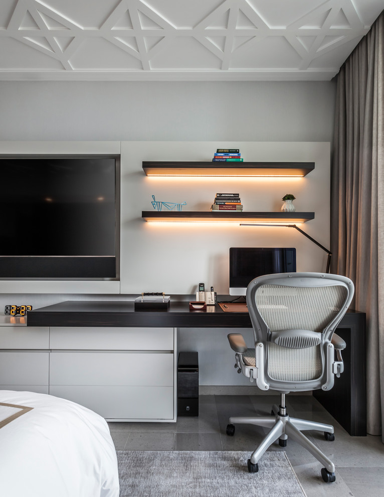 На фото: кабинет в современном стиле с серыми стенами, встроенным рабочим столом и серым полом с