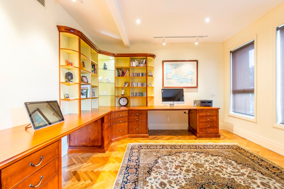 Foto di un grande ufficio chic con pareti bianche, pavimento in legno massello medio, nessun camino e scrivania incassata