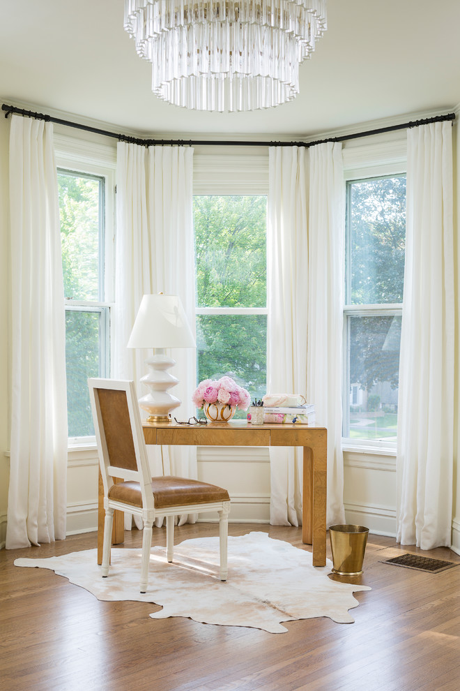 Imagen de despacho clásico pequeño con paredes blancas, suelo de madera en tonos medios y escritorio independiente