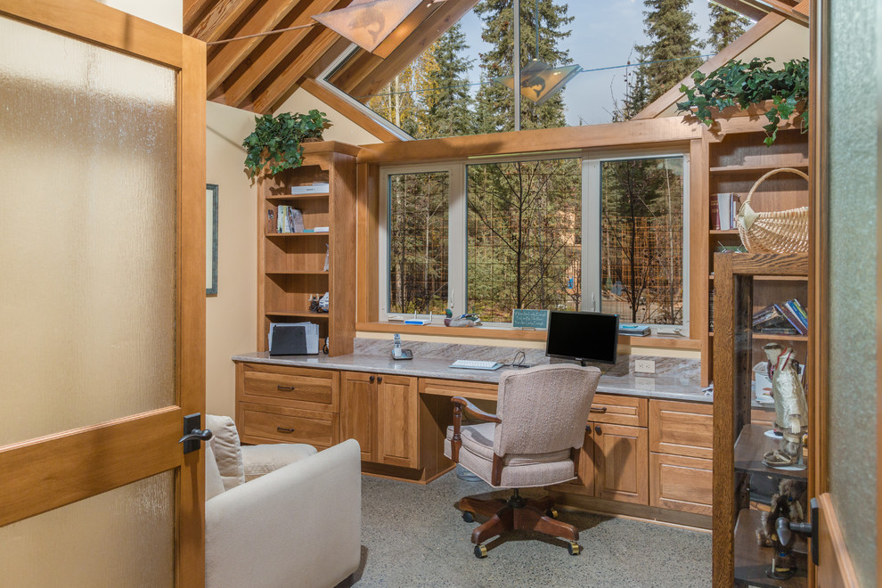 Foto de despacho de estilo americano de tamaño medio sin chimenea con suelo de cemento, escritorio empotrado y paredes beige