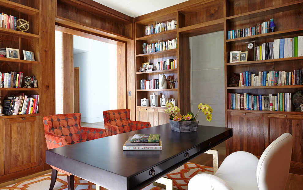 Идея дизайна: домашняя библиотека в современном стиле с коричневыми стенами, паркетным полом среднего тона, отдельно стоящим рабочим столом и коричневым полом