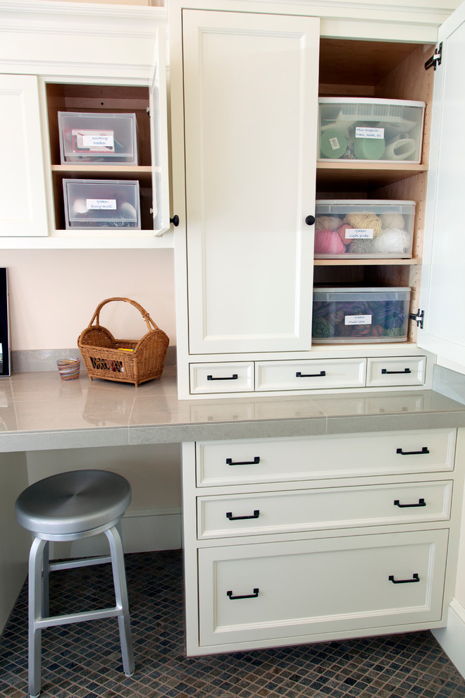 Imagen de sala de manualidades tradicional de tamaño medio con paredes blancas, escritorio empotrado y suelo marrón