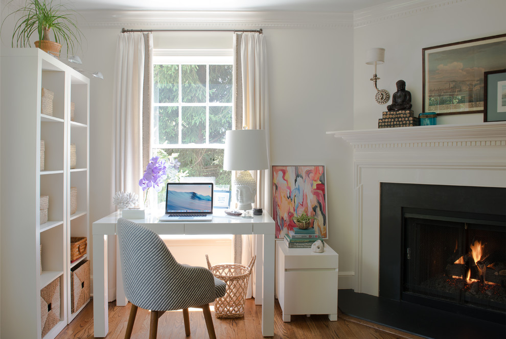 Exemple d'un petit bureau éclectique avec un mur blanc, un sol en bois brun, une cheminée d'angle, un manteau de cheminée en pierre, un bureau indépendant et un sol marron.