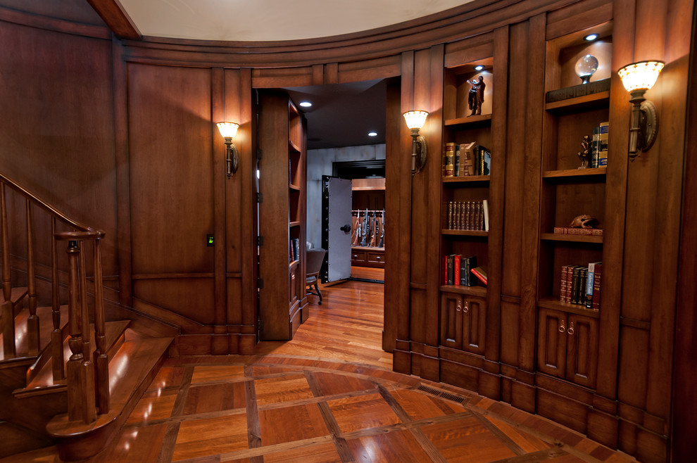 Klassisk inredning av ett mellanstort arbetsrum, med ett bibliotek, bruna väggar, mellanmörkt trägolv och brunt golv