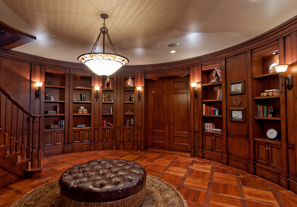 ソルトレイクシティにある中くらいなトラディショナルスタイルのおしゃれなホームオフィス・書斎 (ライブラリー、茶色い壁、無垢フローリング、暖炉なし、茶色い床) の写真