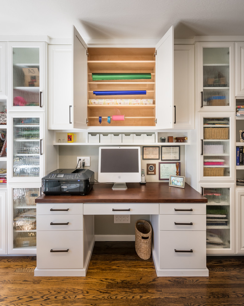 Cette image montre un bureau atelier traditionnel avec un mur gris, parquet foncé et un bureau intégré.