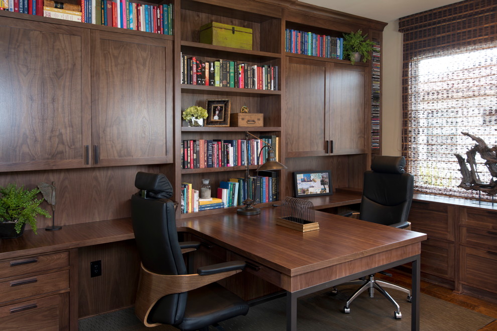 Exempel på ett mellanstort modernt hemmabibliotek, med ett inbyggt skrivbord, beige väggar och mörkt trägolv