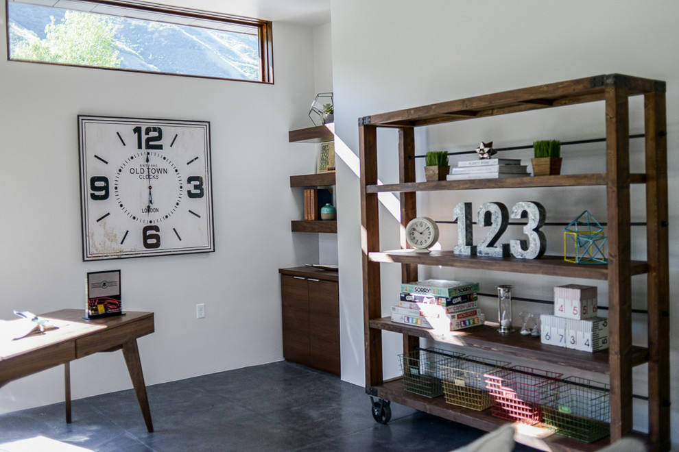 Imagen de despacho minimalista de tamaño medio con paredes blancas y suelo de cemento