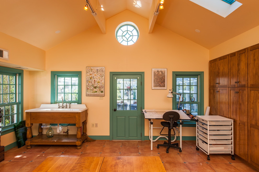 Inredning av ett amerikanskt stort hemmastudio, med beige väggar, klinkergolv i porslin och ett fristående skrivbord
