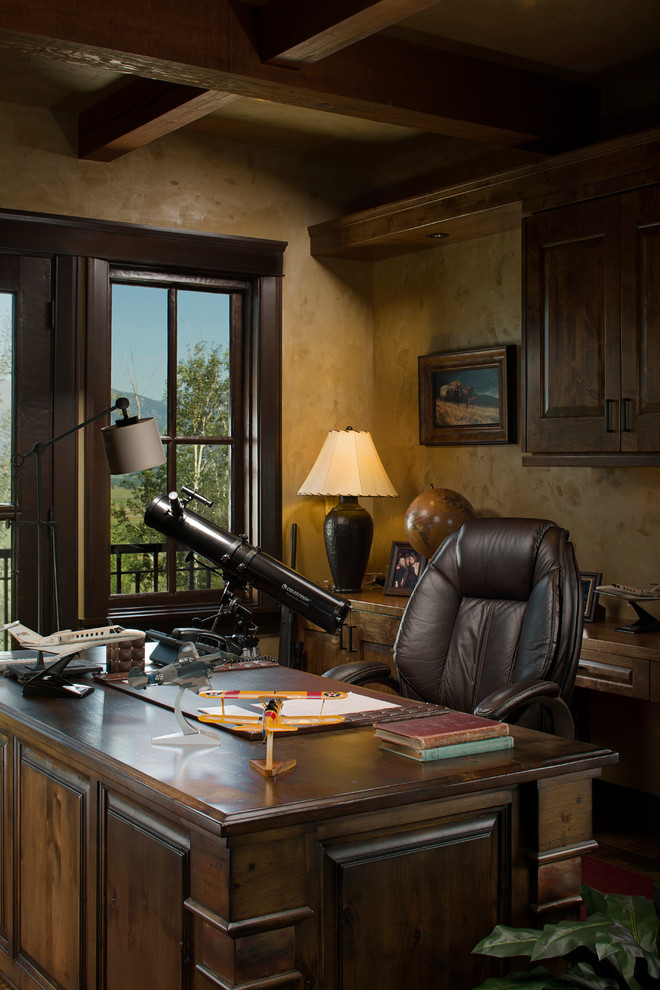 Immagine di un ufficio rustico di medie dimensioni con pareti beige, pavimento in legno massello medio e scrivania autoportante
