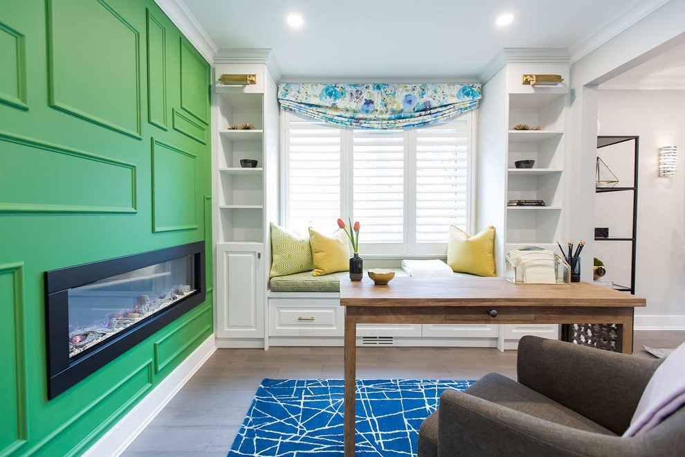 Cette image montre un bureau design avec un mur vert, parquet foncé, un bureau indépendant et un sol marron.